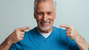 man pointing at his smile with both hands